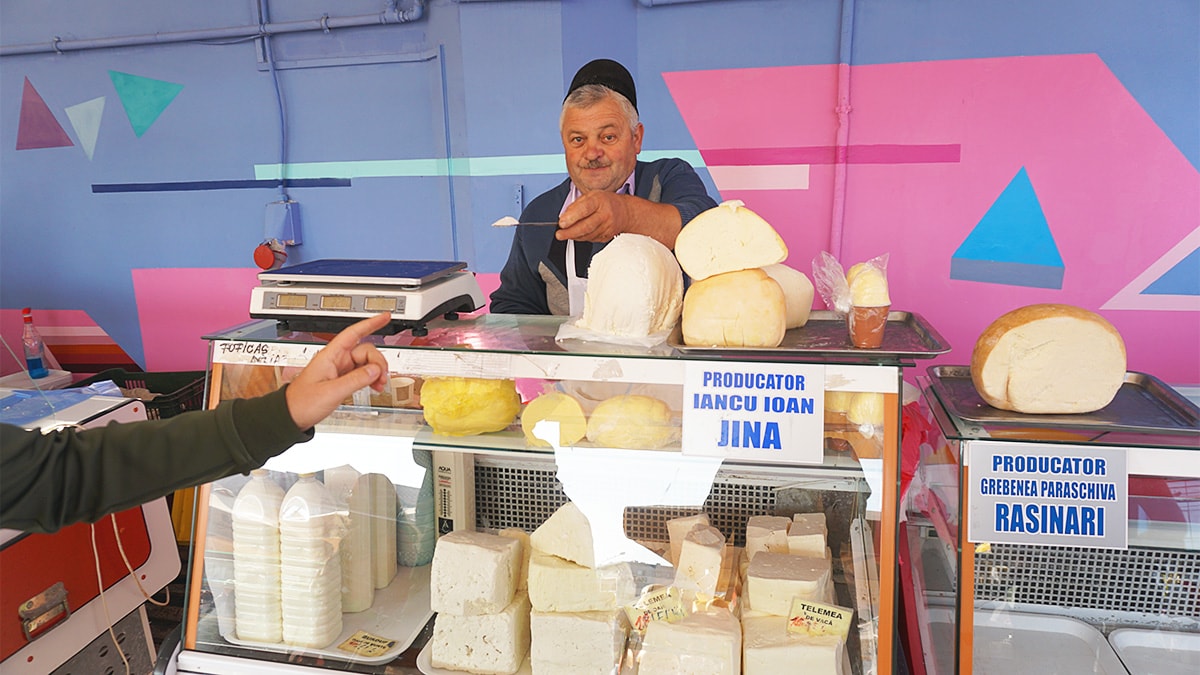 Man offers a sample of local cheese in Romanian village.